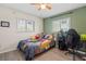 Bright bedroom with a ceiling fan, two windows, light colored walls, and wood floors at 3956 Fairchild Ave, North Port, FL 34287