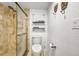 Elegant walk-in shower with tiled surround and glass door, plus a modern commode and wall shelving at 4000 Bal Harbor Blvd # 217, Punta Gorda, FL 33950