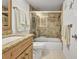Bright bathroom featuring a granite countertop, wood cabinets, and tiled shower with glass doors at 4000 Bal Harbor Blvd # 217, Punta Gorda, FL 33950