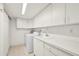 Laundry room featuring washer, dryer, utility sink, white cabinets, and tiled floors at 4000 Bal Harbor Blvd # 217, Punta Gorda, FL 33950