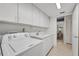 Laundry room with washer, dryer, utility sink, tiled floors, and white cabinets at 4000 Bal Harbor Blvd # 217, Punta Gorda, FL 33950