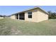 Exterior shot of the backyard featuring a screened in patio, and a large grassy lawn at 4237 Irdell Ter, North Port, FL 34288