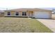 Inviting single-story home featuring a well-maintained lawn, attached garage, and neutral color palette at 4237 Irdell Ter, North Port, FL 34288