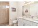 Bathroom featuring a marble sink and a walk-in shower with tan tiles and brown rocks as the flooring at 4450 Northshore Dr, Punta Gorda, FL 33980