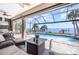Enclosed patio with a swimming pool, outdoor furniture, an outdoor kitchen, and views of the bay at 4450 Northshore Dr, Punta Gorda, FL 33980