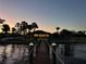 Waterfront home at dusk, featuring a private dock with rope railings and landscape lighting at 4450 Northshore Dr, Punta Gorda, FL 33980