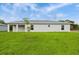 Backyard view of home showcasing a well-maintained lawn and contemporary architecture at 4517 Meager Cir, Port Charlotte, FL 33948