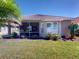 Beautiful backyard featuring lush green lawn, tropical landscaping, and screened patio at 629 Misty Pine Dr, Venice, FL 34292