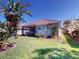 Well-maintained backyard with a lush lawn, mature palm trees, and screened lanai at 629 Misty Pine Dr, Venice, FL 34292