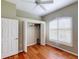 Bedroom with hardwood floors, closet, ceiling fan, and plantation shutters to allow natural light at 629 Misty Pine Dr, Venice, FL 34292