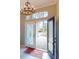 Inviting entryway featuring decorative glass doors, a chandelier, and brick pavers visible beyond the entrance at 629 Misty Pine Dr, Venice, FL 34292