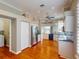 Bright kitchen with stainless steel refrigerator, white cabinets, and hardwood floors adjacent to laundry area at 629 Misty Pine Dr, Venice, FL 34292