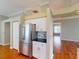 Modern kitchen with stainless steel refrigerator, white cabinets, and hardwood floors blending into adjacent living spaces at 629 Misty Pine Dr, Venice, FL 34292