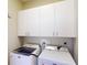 This laundry room features matching Maytag washer and dryer and upper cabinets at 629 Misty Pine Dr, Venice, FL 34292