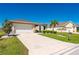 Beautiful single-Gathering home showcasing a two-car garage, manicured lawn, and tropical landscaping at 7081 Waterford Pkwy, Punta Gorda, FL 33950