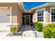 Close-up of the front entrance featuring a decorative screen door and a neatly landscaped walkway at 7081 Waterford Pkwy, Punta Gorda, FL 33950