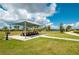 Spacious picnic area beneath a canopy, complete with tables, grill, and green lawns, perfect for community gatherings and outdoor dining at 7081 Waterford Pkwy, Punta Gorda, FL 33950