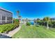 Waterfront backyard featuring lush green grass and a private dock with boat lift at 740 Via Esplanade, Punta Gorda, FL 33950