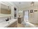 Bright bathroom featuring double sink vanity, tiled floors, and shower with exterior access at 740 Via Esplanade, Punta Gorda, FL 33950