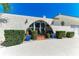 Unique home exterior with an arched entry, lush landscaping, and decorative sun accent at 740 Via Esplanade, Punta Gorda, FL 33950