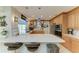 Contemporary kitchen featuring white countertops, oak cabinets, stainless steel appliances, and island seating with pendant lights at 740 Via Esplanade, Punta Gorda, FL 33950