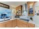 Updated kitchen featuring oak cabinets, white countertops, stainless steel appliances, and stylish decor, with a pass-through to living area at 740 Via Esplanade, Punta Gorda, FL 33950