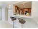 A kitchen pass-through with barstool seating reveals modern cabinets and stainless steel appliances at 740 Via Esplanade, Punta Gorda, FL 33950