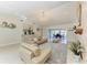 Bright living room features a chandelier, neutral furnishings, and a view of the dining area at 740 Via Esplanade, Punta Gorda, FL 33950