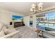 Comfortable living area with chandelier, plush seating, and access to a pool area for relaxation at 740 Via Esplanade, Punta Gorda, FL 33950