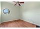 Neutral bedroom with hard wood floors, a ceiling fan, and a round window at 8 Ocean Dr, Punta Gorda, FL 33950