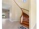 Bright foyer featuring a curved staircase with wooden banister and tile flooring at 8 Ocean Dr, Punta Gorda, FL 33950
