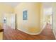 Hallway with wood floors, bright walls, and decorative painting of a bird on the wall at 8 Ocean Dr, Punta Gorda, FL 33950