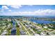 Aerial view of a waterfront community with canals and bay access under a partly cloudy sky at 858 Conreid Ne Dr, Port Charlotte, FL 33952
