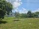 Expansive backyard with lush greenery, mature trees, and a sturdy chain-link fence at 858 Conreid Ne Dr, Port Charlotte, FL 33952