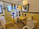 Vintage bathroom with yellow tile, unique sink, and black and yellow shower curtain at 858 Conreid Ne Dr, Port Charlotte, FL 33952