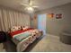 Relaxing bedroom with modern ceiling fan, vibrant floral bedding, and bright natural light at 858 Conreid Ne Dr, Port Charlotte, FL 33952