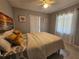 Bright bedroom with tile flooring, modern ceiling fan, and decoratively framed beach artwork at 858 Conreid Ne Dr, Port Charlotte, FL 33952