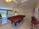 Spacious game room featuring a pool table, stylish bar stools, and ample space for entertaining guests at 858 Conreid Ne Dr, Port Charlotte, FL 33952