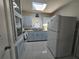 Bright kitchen featuring blue cabinetry, updated appliances, and ample natural light, perfect for cooking and entertaining at 858 Conreid Ne Dr, Port Charlotte, FL 33952