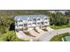 Aerial view showcasing the townhome community with lush greenery, tennis court and inviting living spaces at 10300 Tarpon Landings Ter # 4, Placida, FL 33946