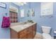 Bathroom featuring a vanity with granite countertop, framed mirror, and light blue walls at 10300 Tarpon Landings Ter # 4, Placida, FL 33946