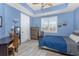 Light-filled bedroom with blue walls, a desk, and a shuttered window at 10300 Tarpon Landings Ter # 4, Placida, FL 33946