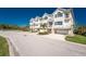 A row of beautiful townhomes with balconies, garages, and lush landscaping under a bright blue sky at 10300 Tarpon Landings Ter # 4, Placida, FL 33946