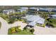An aerial shot reveals the clubhouse's architecture surrounded by lush landscaping and beautiful paved parking at 10300 Tarpon Landings Ter # 4, Placida, FL 33946