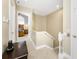 Hallway leading to a bedroom and stairs, featuring neutral tones and tiled flooring at 10300 Tarpon Landings Ter # 4, Placida, FL 33946