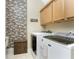 Well-organized laundry room featuring modern washer and dryer and decorative stone accent wall at 10300 Tarpon Landings Ter # 4, Placida, FL 33946