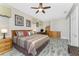 Comfortable main bedroom featuring a ceiling fan, wood floors, dresser and computer desk at 10300 Tarpon Landings Ter # 4, Placida, FL 33946