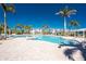 A large community pool surrounded by palm trees, with a brick paver deck and building at 10300 Tarpon Landings Ter # 4, Placida, FL 33946