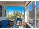 Relaxing screened-in porch with comfortable wicker furniture and a view of lush greenery at 10300 Tarpon Landings Ter # 4, Placida, FL 33946