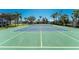 Well-maintained community tennis court surrounded by lush landscaping, ideal for sports enthusiasts at 10300 Tarpon Landings Ter # 4, Placida, FL 33946